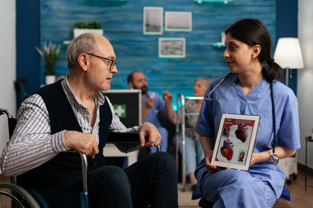 Health specialist explaining cardiac function to elderly patient